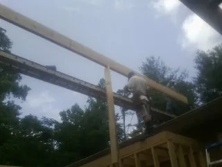 Carpenter setting a ridge beam over a new addition frame — Ice Dam Removal by Roofing Brothers in Elkhorn