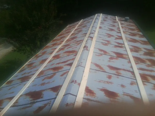 Rusted metal roof panels with new wood purlins before replacement — Storm Damage Roof Repair in Elkhorn by Roofing Brothers