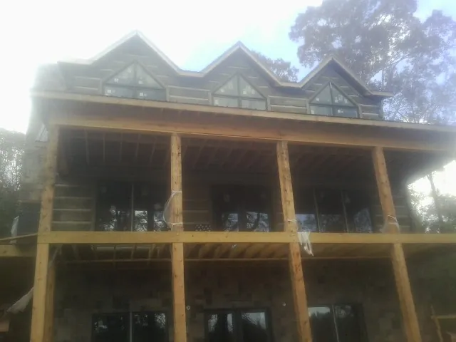 Dormers and porch framing on a large log home under construction — Roof Coating work by our crew in Elkhorn