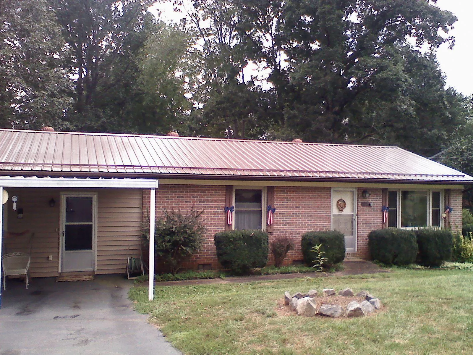 Bronze metal roof and carport on a brick ranch home — Roof Repair work by our crew in Elkhorn